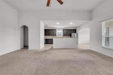 Unfurnished living room with arched walkways, lig