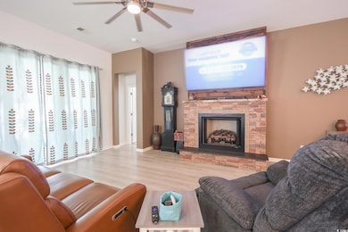Living room featuring visible vents, a ceiling fan