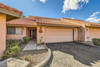 View of front of house with a tiled roof, a garage