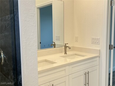 Bathroom featuring double vanity, a textured wall,
