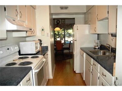 Galley kitchen with cork flooring and refrig with 