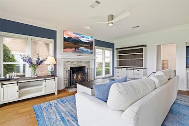Living room with a stone fireplace, visible vents