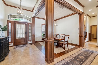 Entrance foyer featuring a chandelier, crown molding, baseboards, and recessed lighting