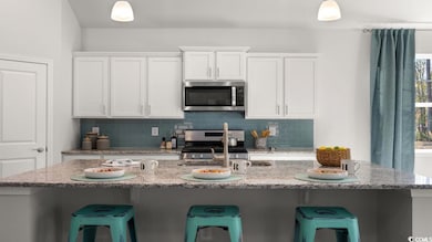 Kitchen featuring white cabinetry, stainless steel
