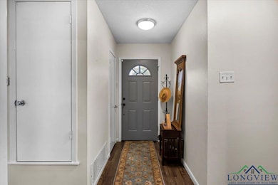 Doorway featuring dark wood finished floors and baseboards