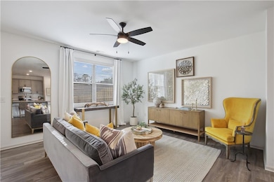 Living room with dark wood-type flooring and ceiling fan