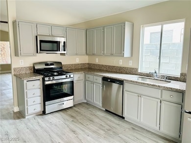 Kitchen with stainless steel appliances, a sink, l