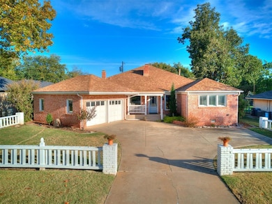 Ranch-style house with brick siding, a fenced front yard, a garage, driveway, and a shingled roof