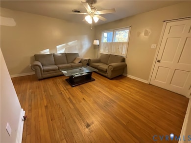 Living room featuring light wood-type flooring and a ceiling fan