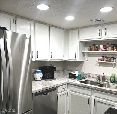 Kitchen featuring white cabinetry, light counterto
