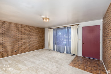 Empty room with brick wall and carpet floors