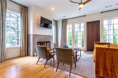 Living room with light hardwood / wood-style floors, a fireplace, and ceiling fan