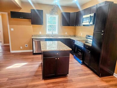Kitchen with light stone counters, a kitchen islan