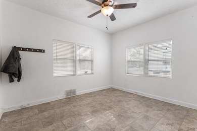Unfurnished room featuring a textured ceiling and ceiling fan