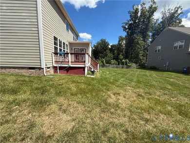 View of green lawn featuring a wooden deck and stairs