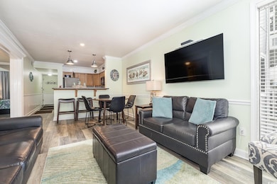 Living room featuring crown molding and light hard