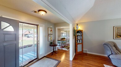 Entryway featuring light wood-style flooring, a chandelier, baseboards, and a textured ceiling