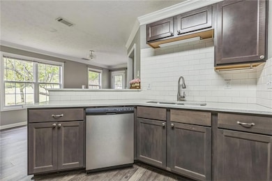 Kitchen featuring a sink, visible vents, dishwashe