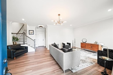 Living area with a chandelier, stairs, light wood-type flooring, crown molding, and recessed lighting
