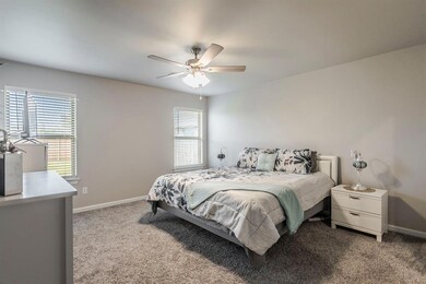 Carpeted primary bedroom with ceiling fan