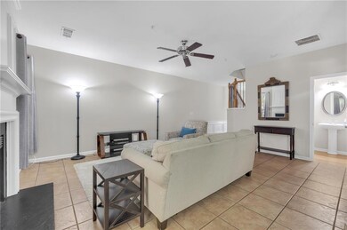 Living area with light tile patterned floors and a ceiling fan