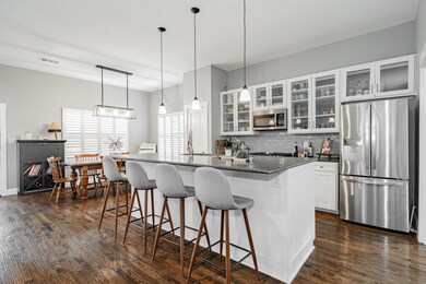 Kitchen with a kitchen bar, white cabinetry, dark 