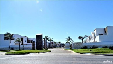 View of asphalt street with curbs, a residential view, sidewalks, and a gated entry