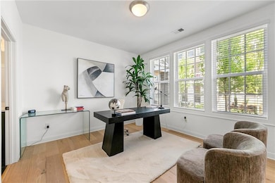 Office space with light wood-type flooring and baseboards