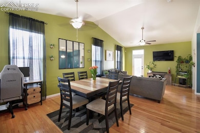Dining area featuring lofted ceiling, light wood-style flooring, a ceiling fan, and baseboards