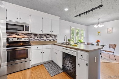 Kitchen featuring rail lighting, kitchen peninsula