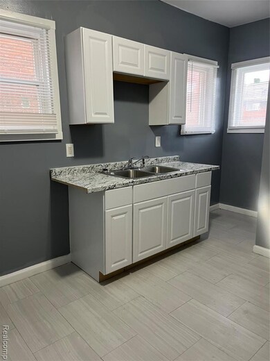 Kitchen with white cabinetry and wood tiled floors