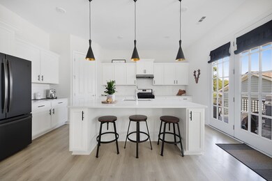 Gorgeous kitchen with designer lighting, upgraded cabinets, quartz counters, high end appliances, gas range, and easy indoor/ outdoor entertaining with beautiful doors to the back deck and yard.