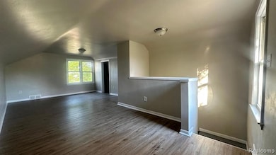 Bonus room featuring lofted ceiling and dark wood-type flooring