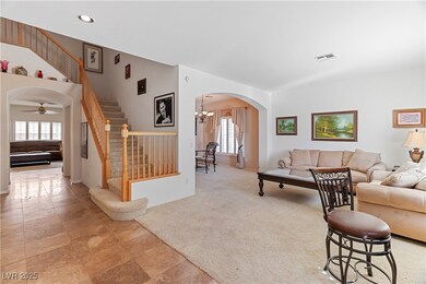 Living area with stairway, arched walkways, healthy amount of natural light, light colored carpet, and recessed lighting