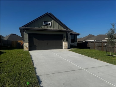 View of front of house featuring stone siding, board and batten siding, and concrete driveway