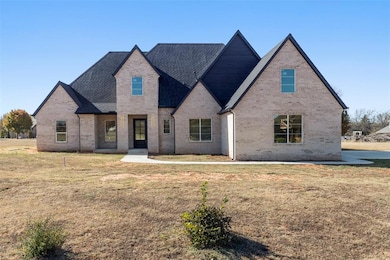 View of front of house with brick siding, a front yard, and a shingled roof