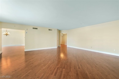 Spare room with a chandelier and hardwood / wood-s