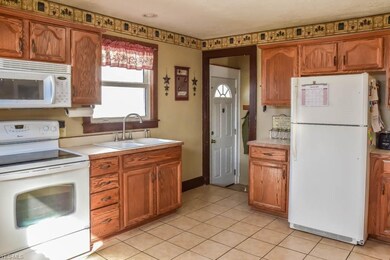 Applianced kitchen with tile flooring.