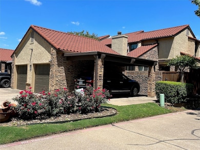 View of front of house with a chimney, stucco siding, an attached garage, and a tile roof