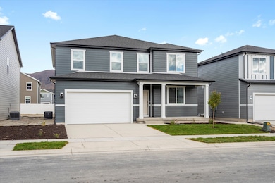 Traditional-style home featuring roof with shingles, a porch, a garage, and driveway