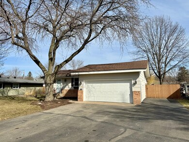The driveway is extra wide and deep along the garage.