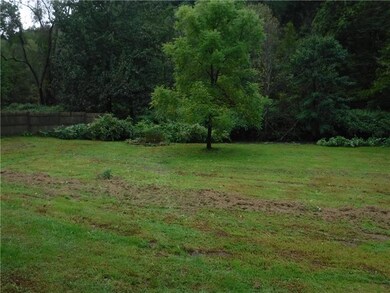 Backyard with fence on one side and stream in back