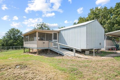 Rear view of property with a lawn and a sunroom