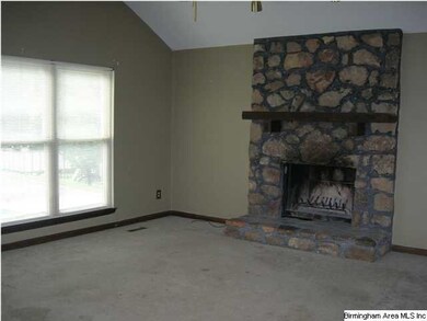 Greatroom with vaulted ceiling and wood burning fi