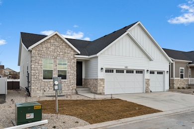 View of front of house with stone siding, board and batten siding, and concrete driveway