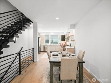 Beautiful, bright dining & kitchen with floating staircase.