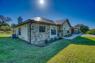 View of side of home with stone siding, metal roo
