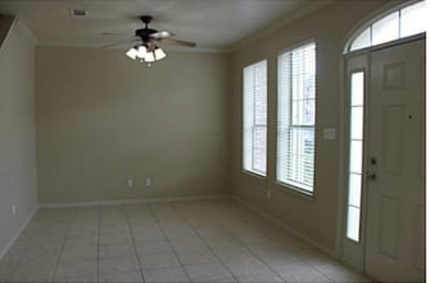Entryway featuring crown molding, light tile patterned floors, and ceiling fan