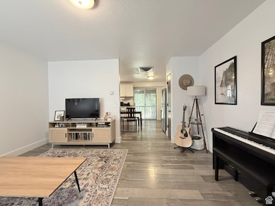 Living area with a textured ceiling and light wood finished floors