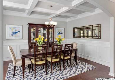 You can entertain with style in this elegant formal dining room. Dramatic coffered ceiling, dark wood flooring, raised panel wainscoting, and arched entryway set the stage for memorable celebrations with friends and family.